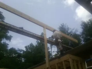 Carpenter setting a ridge beam over a new addition frame — Ice Dam Removal by Roofing Brothers in West Suffield