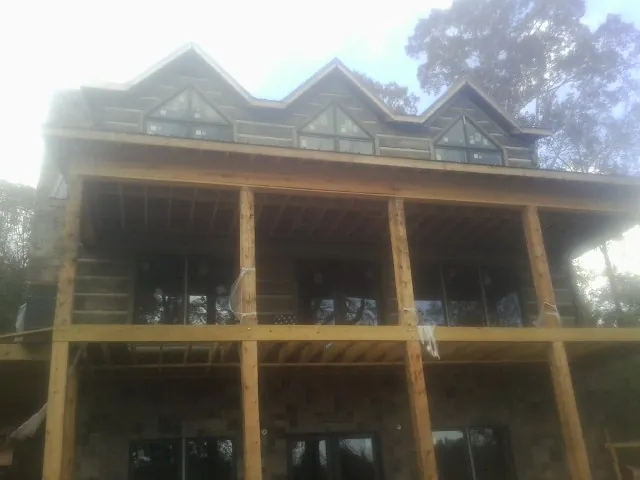 Dormers and porch framing on a large log home under construction — Roof Coating work by our crew in West Suffield