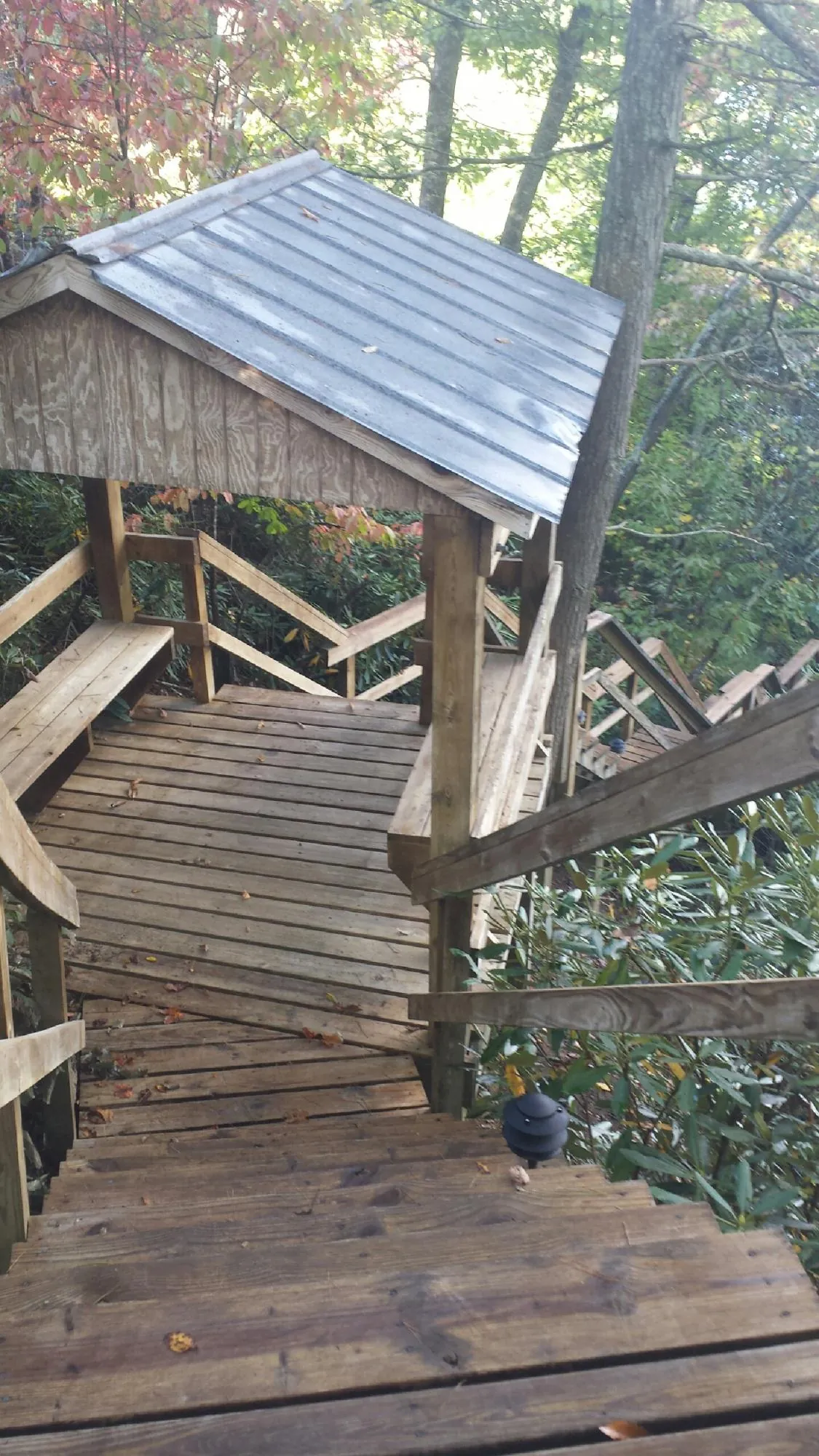 Metal roofed shelter over wooden steps on a wooded walkway — Skylight Repair & Installation work by our crew in West Suffield
